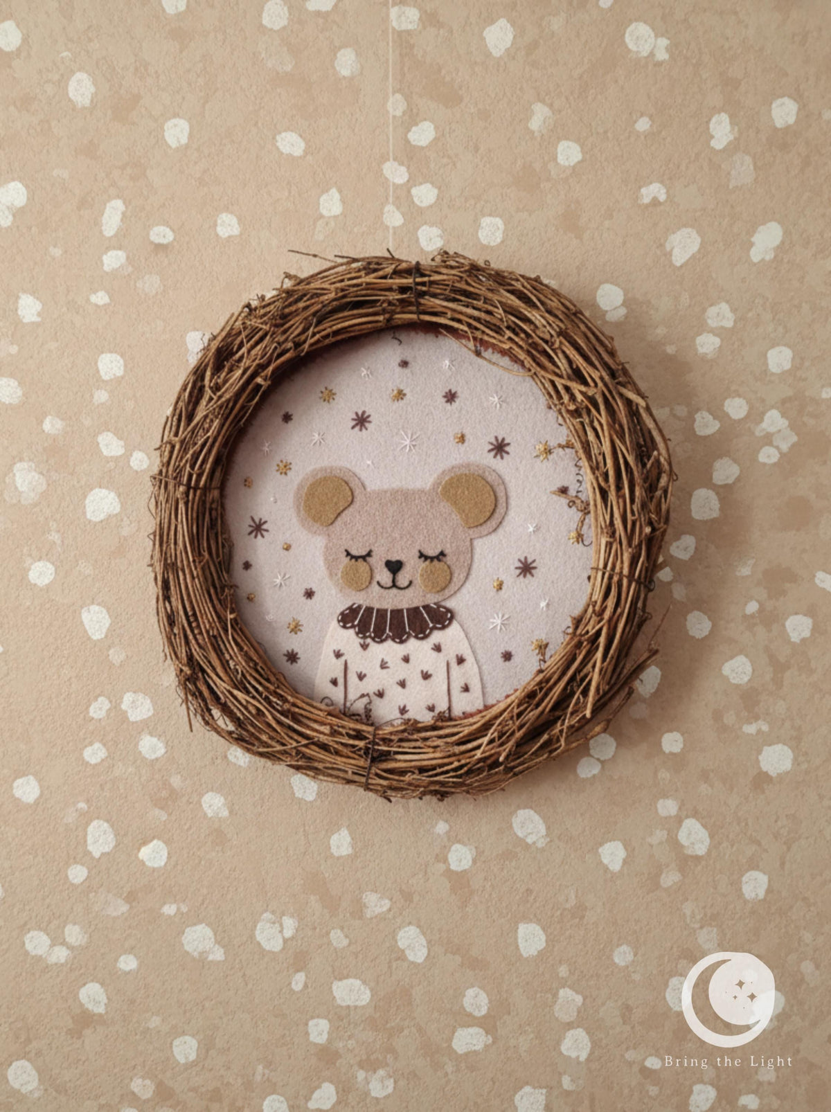 Mouse portrait with round ears and a dark collar inside a twig ring
